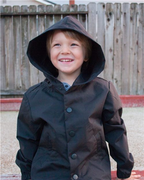 child model in independent youth hooded windbreaker coachs jacket in black