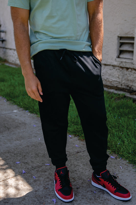 model wearing independent trading co fleece pants in black