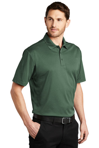 model wearing port authority heathered silk touch polo in green glen heather