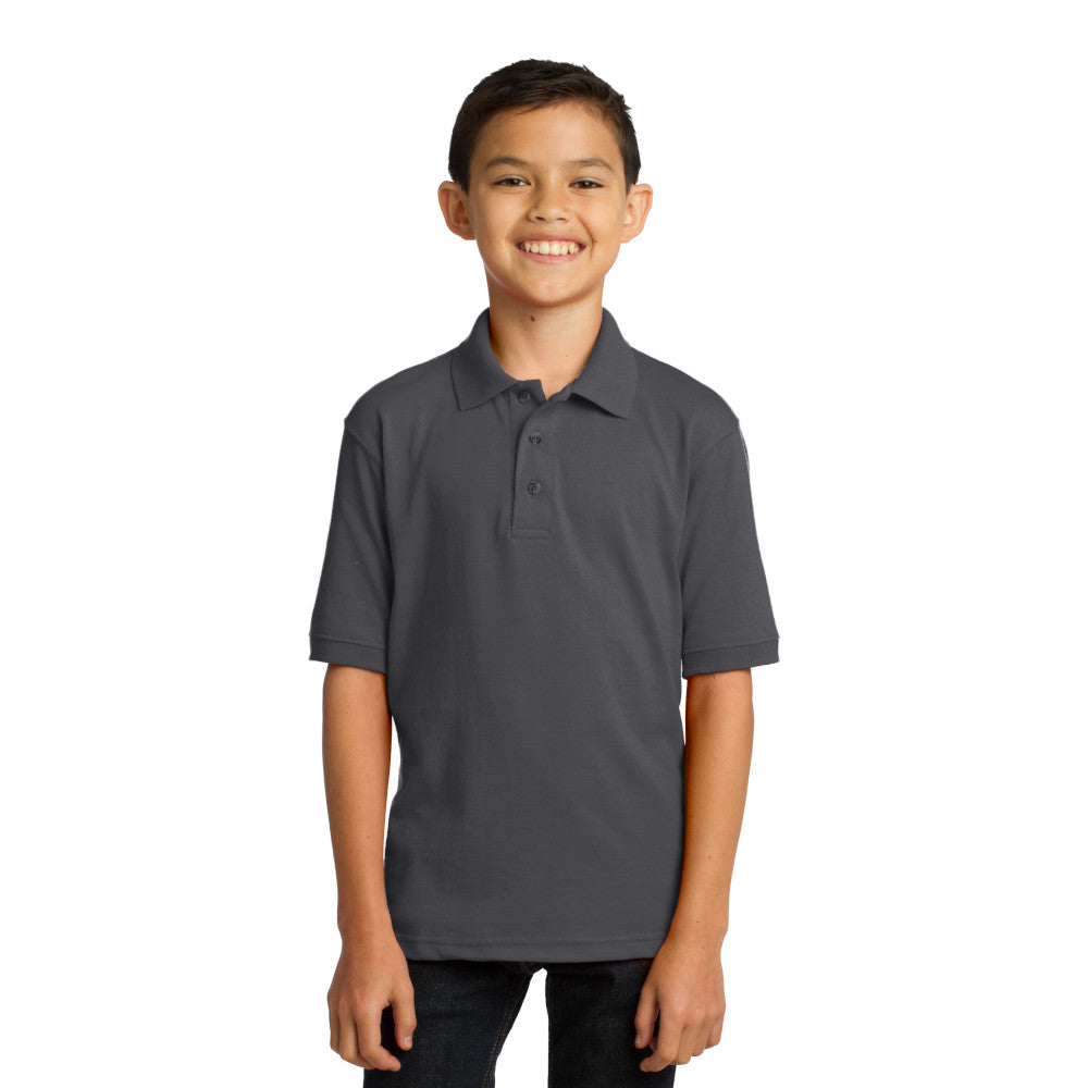 smiling child model wearing port & company youth knit polo in charcoal