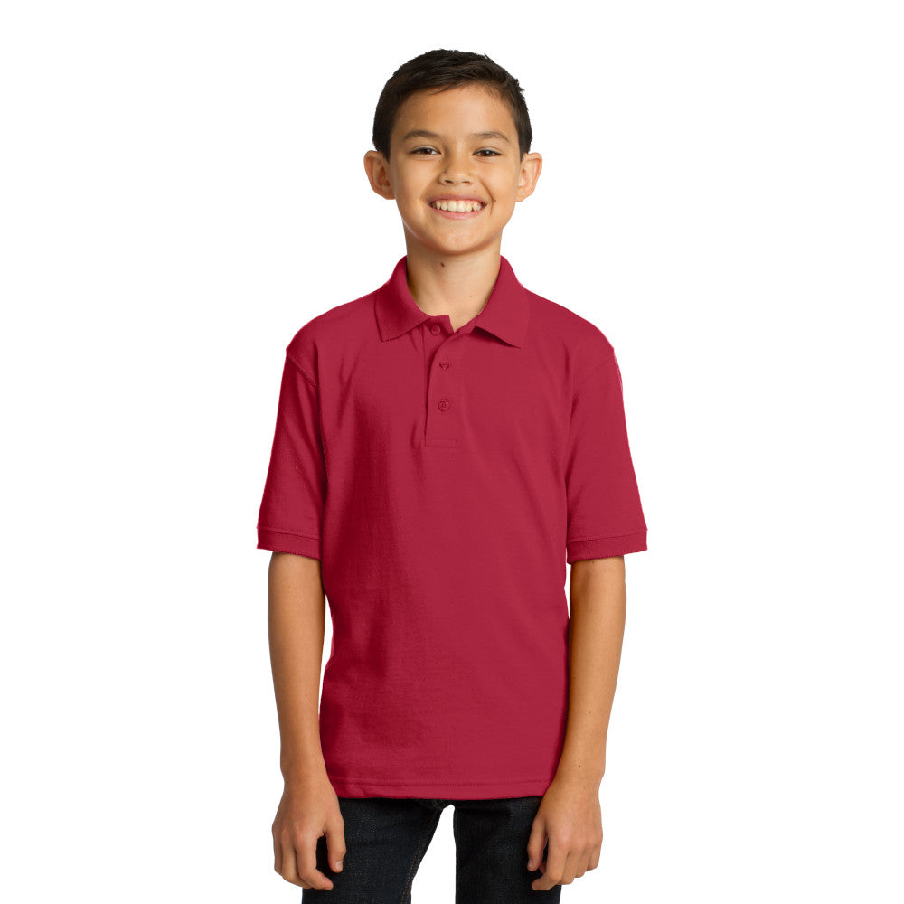 smiling child model wearing port & company youth knit polo in red