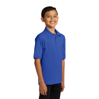 smiling child model wearing port & company youth knit polo in royal