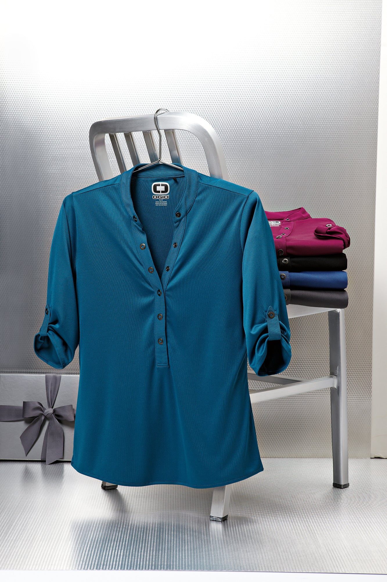 ogio womens crush henley polos hanging and folded on a metal chair